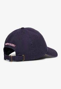 Gorra de béisbol de algodón azul marino con correa ajustable, con el logo bordado en rosa "SUPERDRY" en la parte posterior. Visera curva y detalles cosidos.