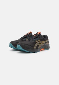 Baskets de sport noires avec une tige texturée, des accents orange et turquoise, et une semelle robuste conçue pour l'adhérence. Comprend des lacets et des détails de logo.