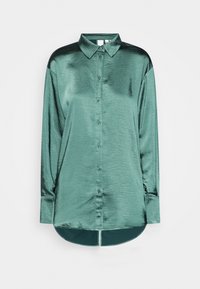 Camisa de satén verde de manga larga con cuello clásico, cierre frontal con botones y dobladillo redondeado. Textura suave, diseño minimalista y un brillo sutil.