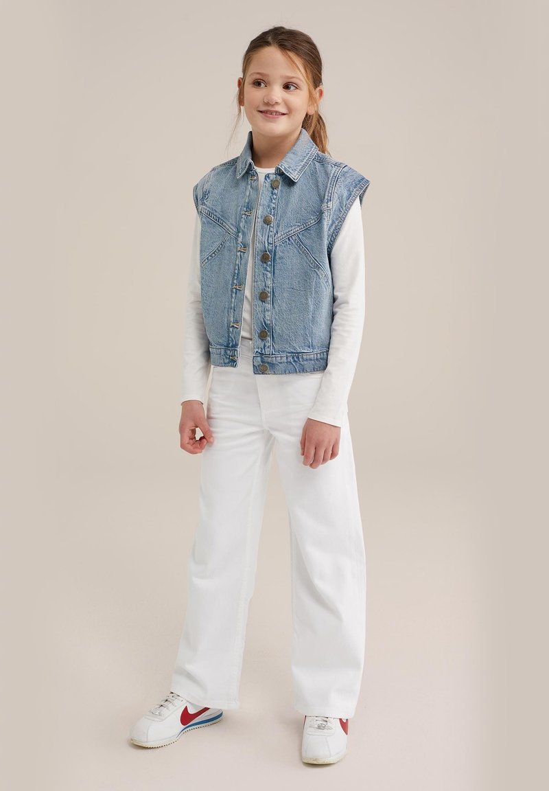 Denim veste ar gaiši zilu mazgājumu, ar smailu apkakli, pogu aizdari un divām krūšu kabatām. Apvienota ar baltām brīvām biksēm un kedām.