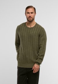 Sweter w kolorze khaki, wykonany w splot kabelkowy, z długimi rękawami, okrągłym dekoltem oraz ściągaczami przy mankietach i dole. Uszyty z teksturowanej tkaniny. Idealny na codzienne okazje.