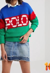 Stickad tröja med röda, blå och gröna horisontella ränder samt "POLO"-logotyp; kombinerad med en fransad denimkjol.