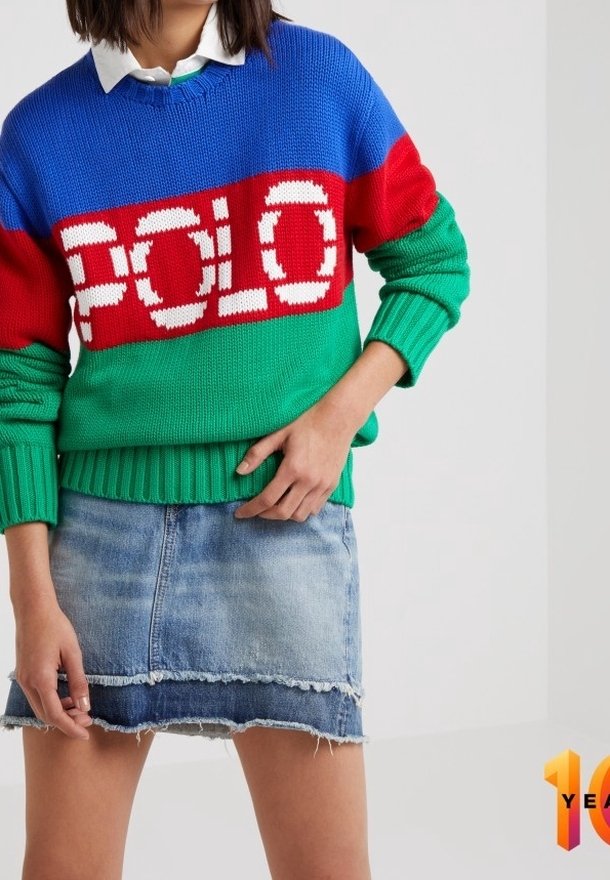 Stickad tröja med röda, blå och gröna horisontella ränder samt "POLO"-logotyp; kombinerad med en fransad denimkjol.