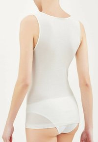 Canotta bianca senza maniche realizzata in materiale morbido, con un design aderente e una consistenza liscia. Nessun motivo o hardware visibile.