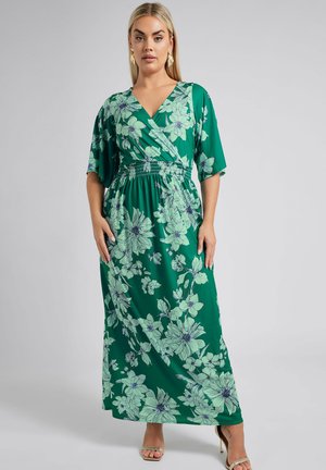 Vestido maxi de tela verde con un patrón floral en azul claro y púrpura. Presenta un escote en V, mangas cortas y una cintura fruncida.