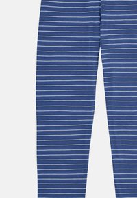 Leggings azules hechos de una tela suave con finas rayas horizontales blancas. El diseño se extiende hasta la longitud completa con una forma ajustada.