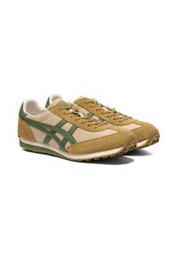 Un paio di sneakers atletiche in suede beige e verde oliva, con suola testurizzata e lacci, angolate a destra su sfondo bianco.