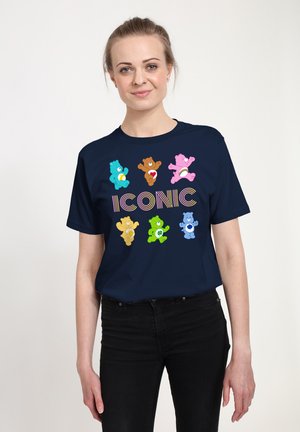 T-shirt en coton bleu marine avec des graphiques colorés d'ours et le mot "ICONIQUE" en lettres arc-en-ciel sur le devant. Manches courtes, coupe décontractée.