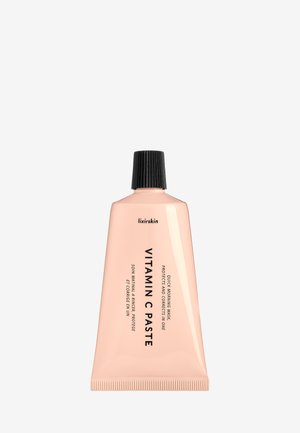 Tube de couleur pêche de la pâte à la vitamine C Lixirskin avec un bouchon à vis noir, étiquetée comme masque matinal rapide qui protège et corrige la peau.