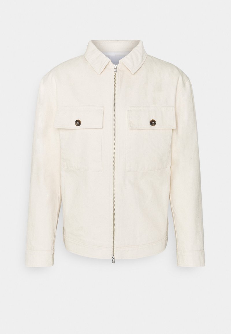 Veste écrue avec fermeture éclair frontale, deux poches poitrine à rabat boutonné, manches longues et col classique sur un fond uni.