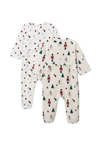 Deux grenouillères pour bébé : une blanche avec de petits motifs rouges et verts, l'autre beige clair avec de plus grands dessins de casse-noisette et de bonhomme de neige.
