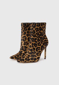 Luipaardprint enkellaarsjes met een puntige neus, gemaakt van getextureerd nepbont, met een stiletto-hak en een zwarte rand bovenaan.