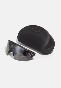 Schwarze Sportsonnenbrille mit einem geschwungenen Design und getönten grauen Gläsern, begleitend zu einem harten schwarzen Etui zur Aufbewahrung und zum Schutz.