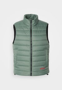 Vesta padding de culoare verde deschis, cu guler înalt și fermoar frontal. Prezintă panouri laterale negre și un logo roșu "HUGO" pe față.