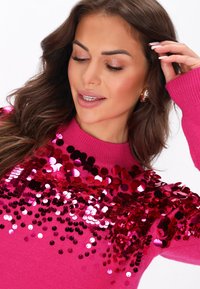 Pulover fuchsia cu paiete rotunde în nuanțe variate de roz, design dispersat pe partea superioară din față. Material tricotat, mansete ribbate.