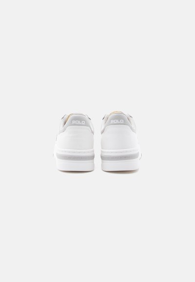 Paire de baskets blanches Polo Ralph Lauren vues de dos sur un fond gris clair uni.