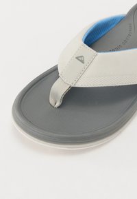 Grå flip-flop med en teksturert såle og en lys grå rem. Remmen har en blå kant og en subtil logo-detalj.