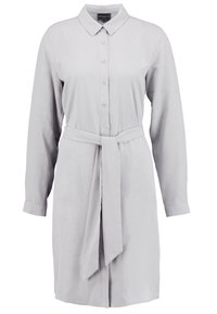Vestito camicia grigio chiaro con colletto, bottoni frontali, maniche lunghe e una cintura legata in vita; tessuto morbido con una leggera lucentezza.