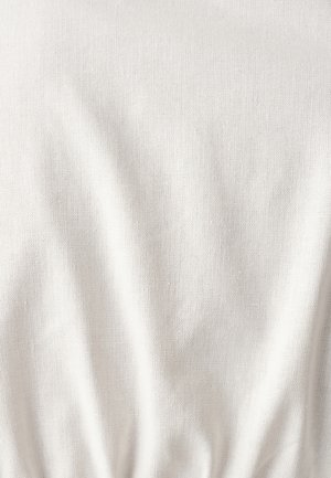Helles beiges Material mit einer strukturierten Oberfläche, das subtile Falten und Knitter aufweist. Der Stoff wirkt weich und leicht.