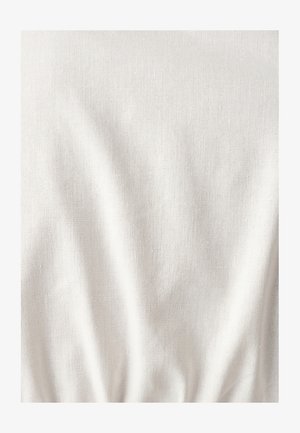 Helles beiges Material mit einer strukturierten Oberfläche, das subtile Falten und Knitter aufweist. Der Stoff wirkt weich und leicht.