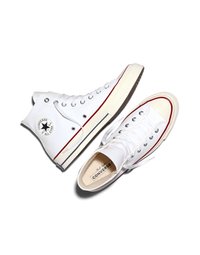 Par de zapatillas blancas Converse All Star de caña alta con franjas rojas y negras en la suela, cordones blancos y parche con el logo en el tobillo.