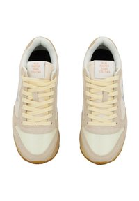 Beige Sneaker mit gelben Schnürsenkeln und Akzenten. Verfügt über ein Obermaterial aus Mesh und Wildleder, eine Gummisohle und ein Etikett mit dem Text "LAUFEN SIESCHNELLER ALS SIE KÖNNEN."