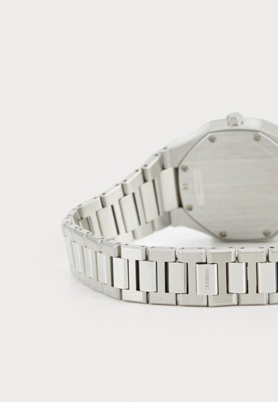 Orologio in metallo argentato con cassa ottagonale e cinturino a maglie, caratterizzato da superfici spazzolate e lucide, che mostra un retro pulito.