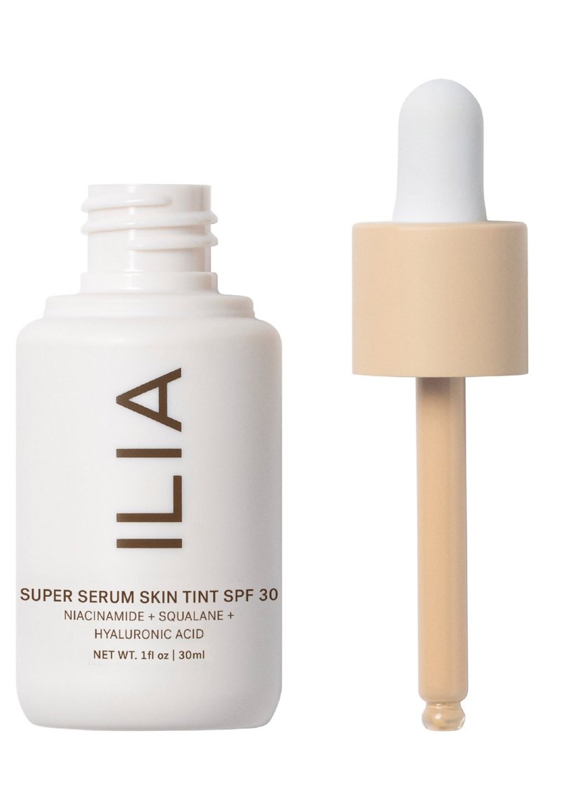 Flaska med ILIA Super Serum Skin Tint SPF 30 i vitt med bruna bokstäver. Har ett beige lock och pipettapplicator. 30 ml storlek.