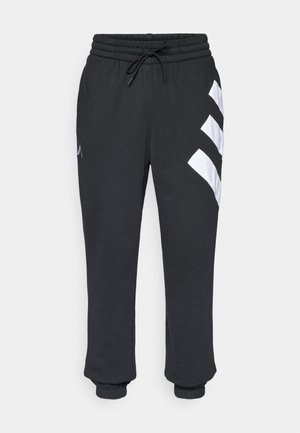 Zwarte trainingsbroek met een elastische tailleband, trekkoord en witte diagonale strepen op het linkerpand, met een boord bij de enkels.