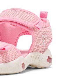 Rosa mesh sandal med kardborreband, en vadderad sula och rundade utskärningar för andningsförmåga. Har logotypdetalj på sidan.