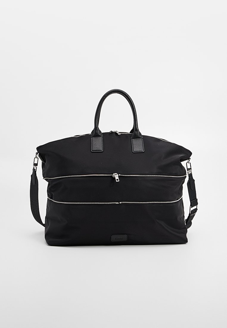 Bolso de lona negro con dos bolsillos frontales con cremallera, dos asas superiores y una correa para el hombro desmontable. Presenta una textura suave y herrajes plateados.