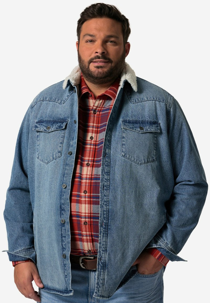 Camicia di jeans con colletto in sherpa beige. Presenta due tasche sul petto e una vestibilità rilassata sopra una camicia a quadri rossa e crema.