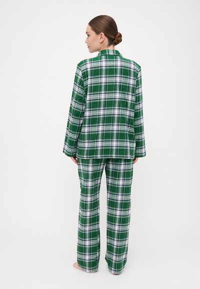 Green plaid pajama set featuring a long-sleeve top and matching pants with white accents, made of soft fabric with a relaxed fit.