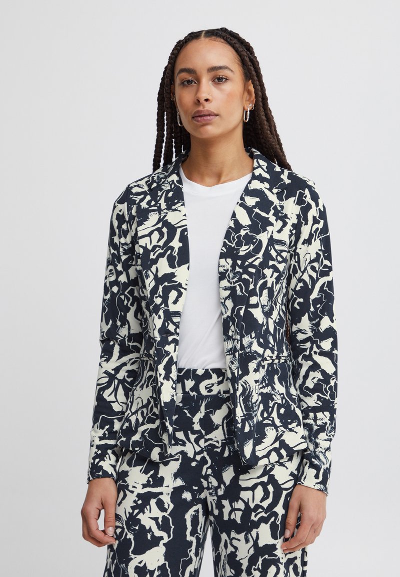 Marineblauw en crèmekleurig geblokt blazer met een getailleerde pasvorm, voorzien van een geknipt kraag, twee voorzakken en een zachte, gestructureerde stof.