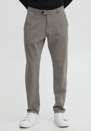 Light grey, tailored trousers with a textured weave, a single button closure, and side pockets, worn with white sneakers.