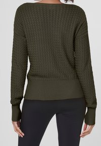 Pull en tricot vert olive avec un motif zigzag texturé, des poignets et un ourlet côtelés, et une coupe décontractée.