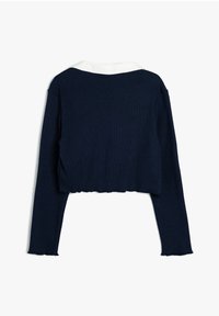 Marineblå cropped sweater med lange ærmer, struktureret strikstof og en kontrasterende hvid krave. Ujævn søm detalje.