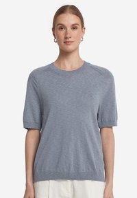 Ljusblå stickad kortärmad tröja med rundad hals, ribbade muddar och nederkant, med en slät textur och en avslappnad passform.