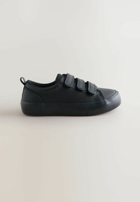 Czarne trampki z gumową podeszwą, trzema paskami na rzep, górną częścią z gładkiego tworzywa sztucznego, okrągłym noskiem i małą pętelką na pięcie ułatwiającą zakładanie.