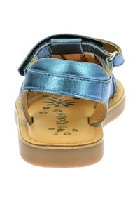 Sandalias metálicas azules con dos correas ajustables, diseño abierto en la parte delantera, plantilla acolchada de color marrón claro y patrón decorativo de flores en la base.