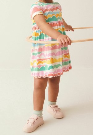 Farverig kjole med bølget mønster i pink, grøn, gul og blå, med korte ærmer og en flæset kant. Pink sneakers med velcro-stropper.