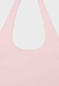 Sac à épaule en tissu rose clair avec une large bandoulière et une ouverture arrondie en haut sur un fond blanc uni.