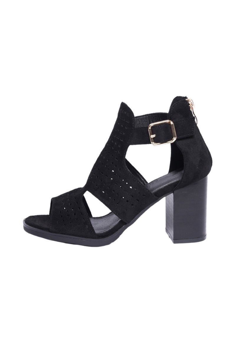Sandalo alto in suede nero con design perforato. Punta aperta e cinturino alla caviglia con fibbia dorata. Tacco a blocco e interno liscio.