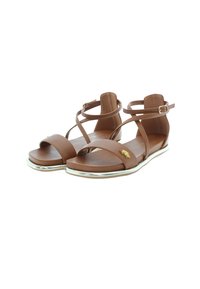 Ruske läder sandaler med korsande remmar, platt sula och metallisk silverkant. Har en liten guld logotypdetalj på en rem.