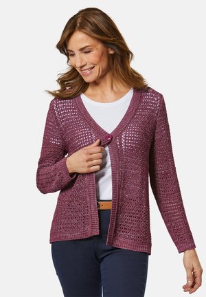 Strickcardigan in tiefem Burgunderrot mit offener Webstruktur, V-Ausschnitt, einem Knopfverschluss und langen Ärmeln, kombiniert mit einem weißen Hemd.