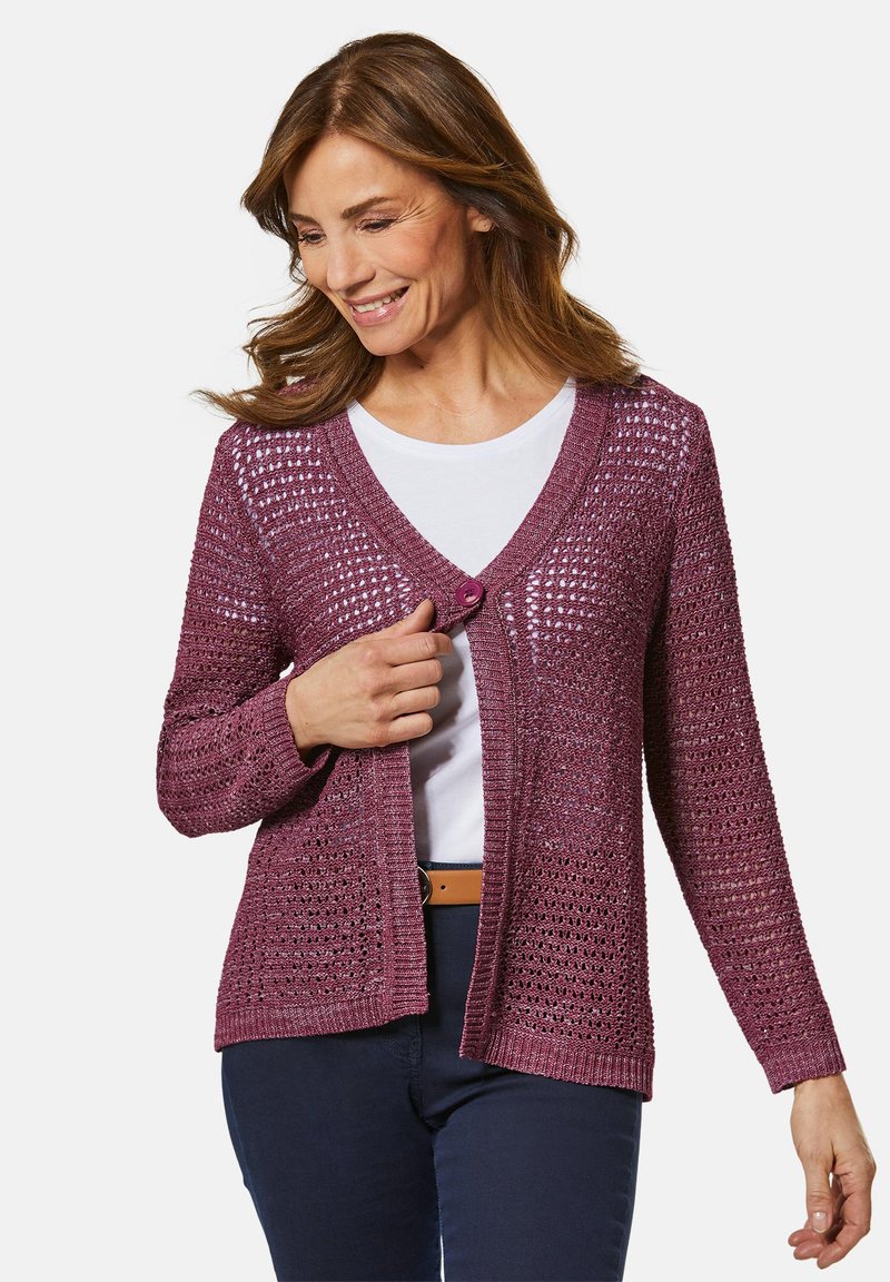 Strickcardigan in tiefem Burgunderrot mit offener Webstruktur, V-Ausschnitt, einem Knopfverschluss und langen Ärmeln, kombiniert mit einem weißen Hemd.