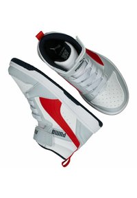 Weiße Sportschuhe mit roten Akzenten, einem strukturierten Obermaterial aus Leder, einer gepolsterten Zunge und einer Gummisohle. Verfügt über ein Logo und eine Zuglasche an der Ferse.