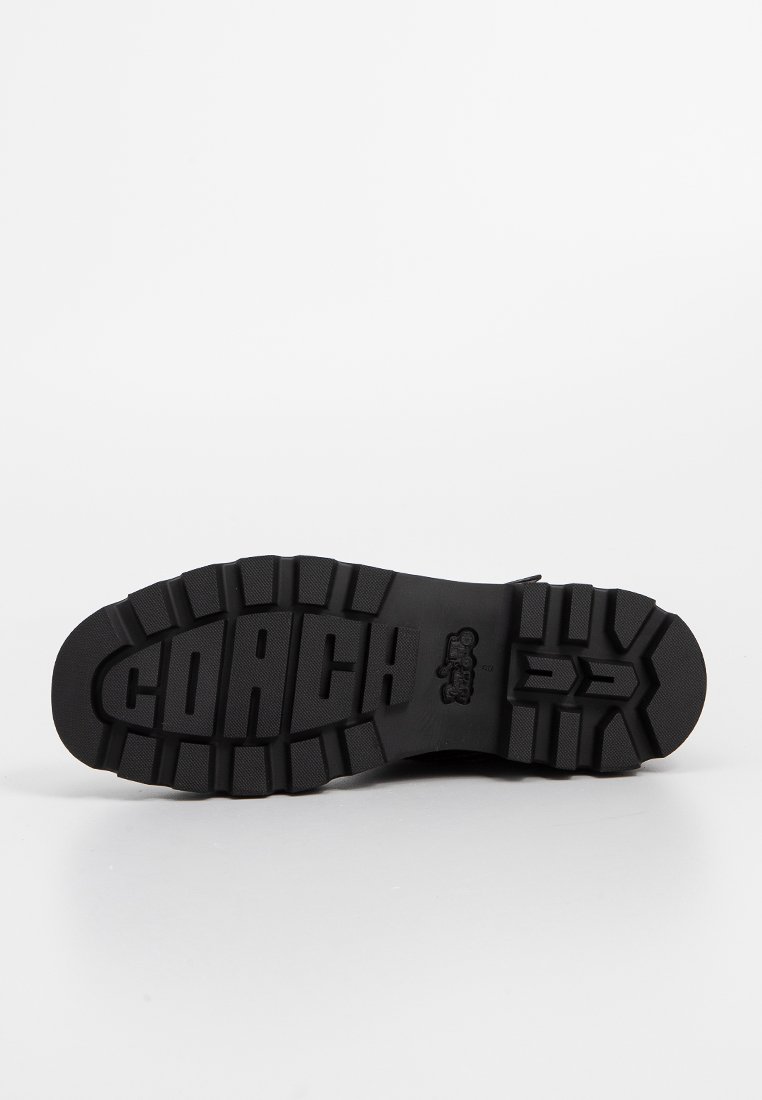 Schwarze Gummisohle mit strukturiertem Profil. Verfügt über das "COACH"-Logo und ein rutschfestes Design für verbesserten Halt.