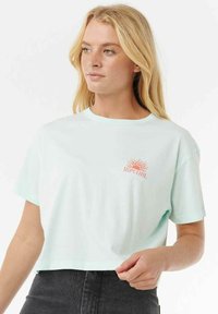 Licht mintgroene cropped t-shirt van zachte stof. Heeft korte mouwen en een kleine rode zonafbeelding met de tekst "Rip Curl" op de borst.