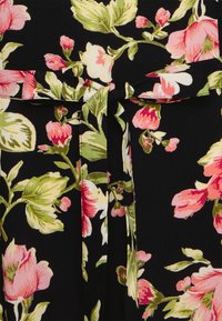 Vestido preto floral com grandes padrões de flores em rosa e verde, com detalhe de cintura atada e textura de tecido suave.